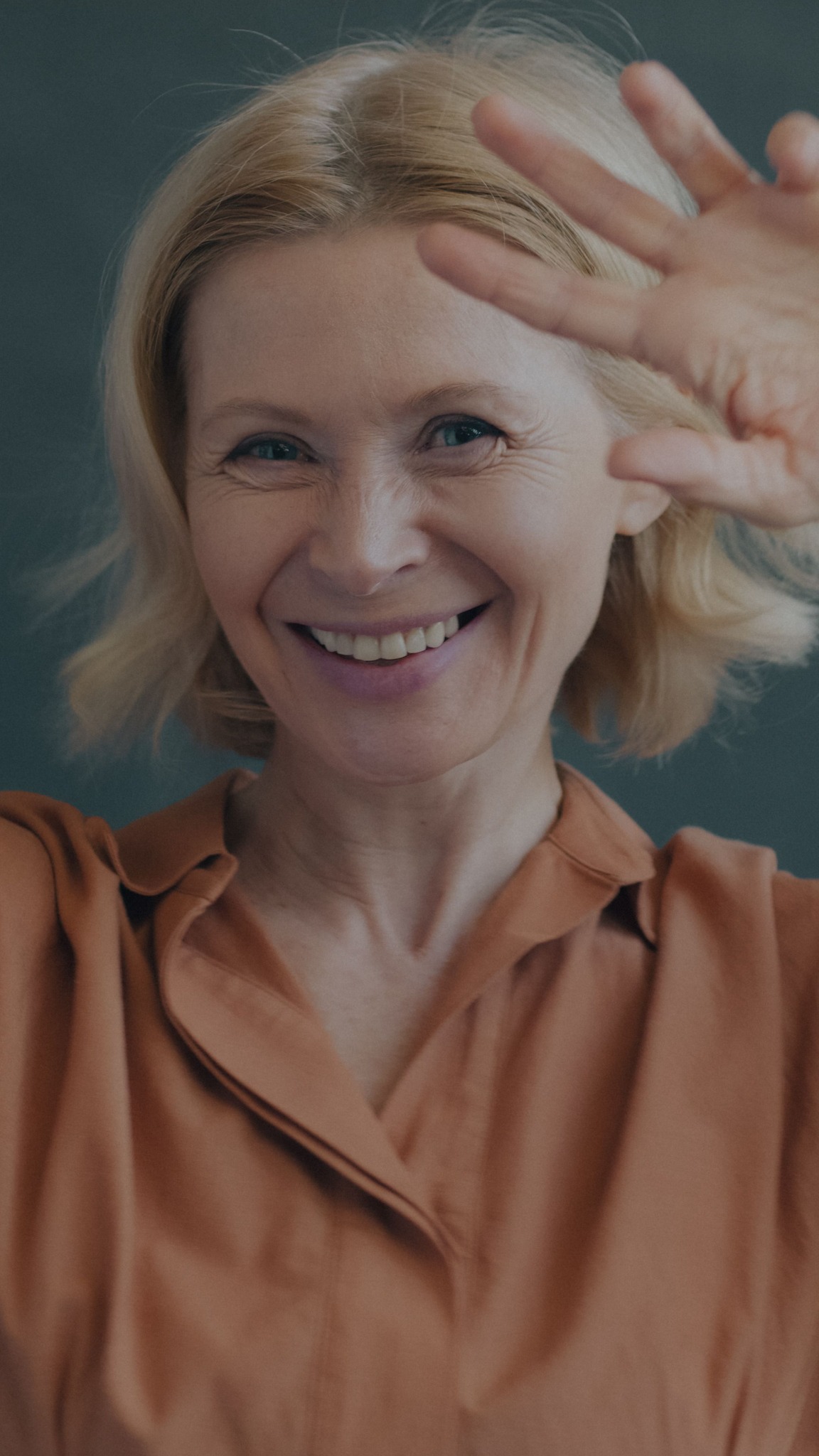 A woman smiling and waving